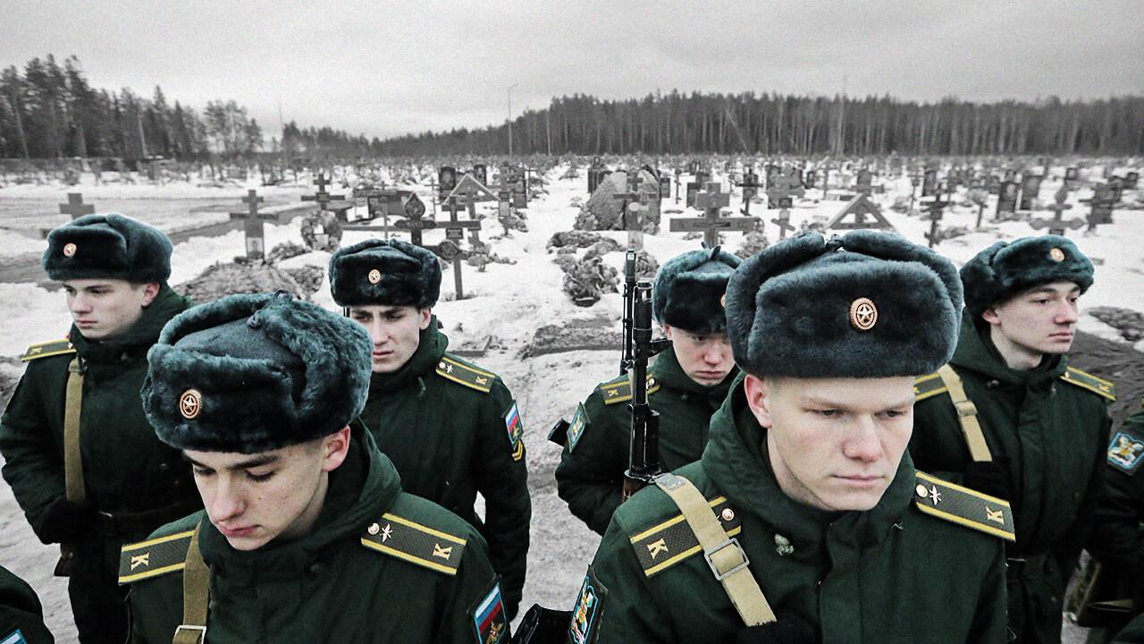 Foto de cadetes russos em pé em um cemitério