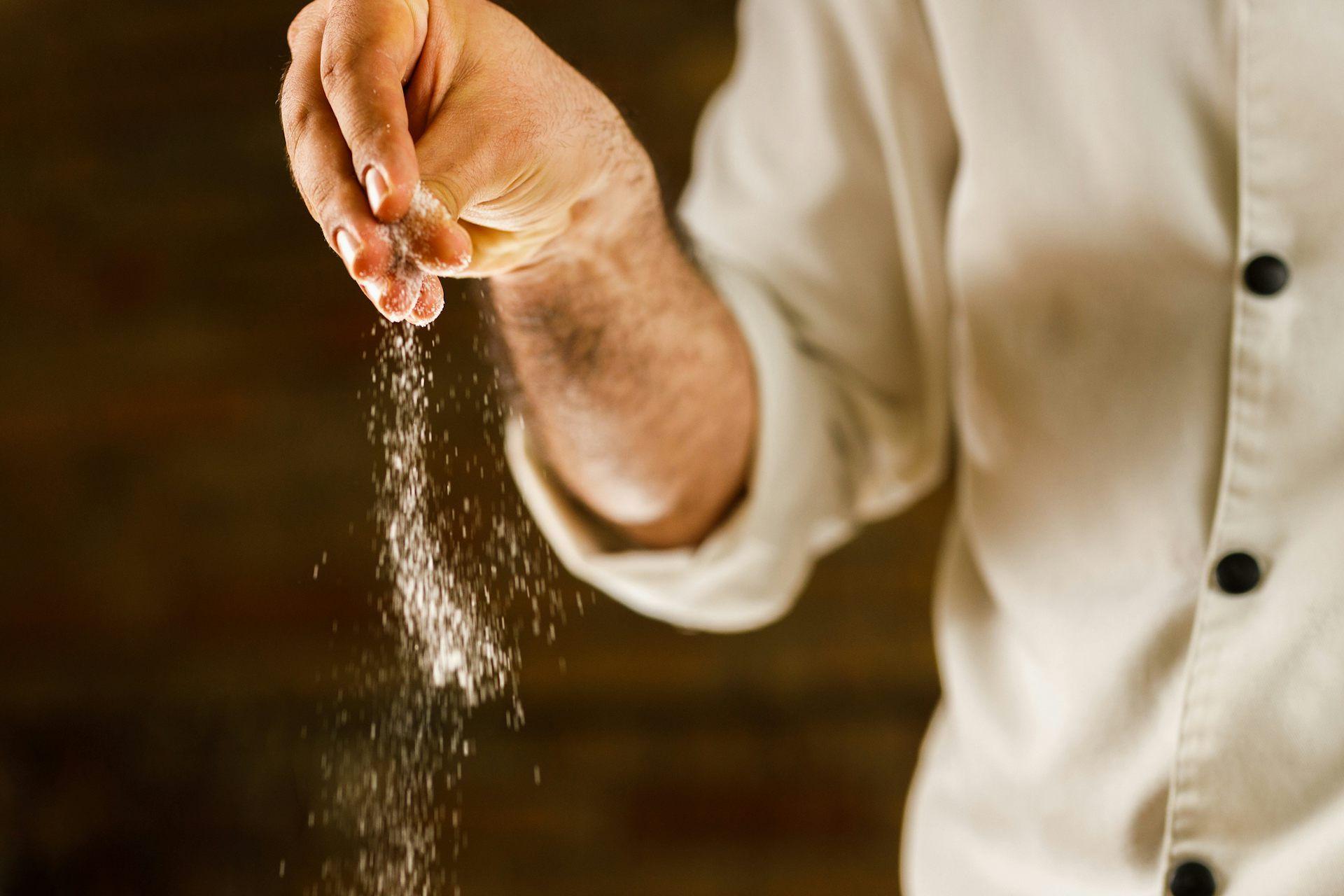 Una mano esparciendo sal
