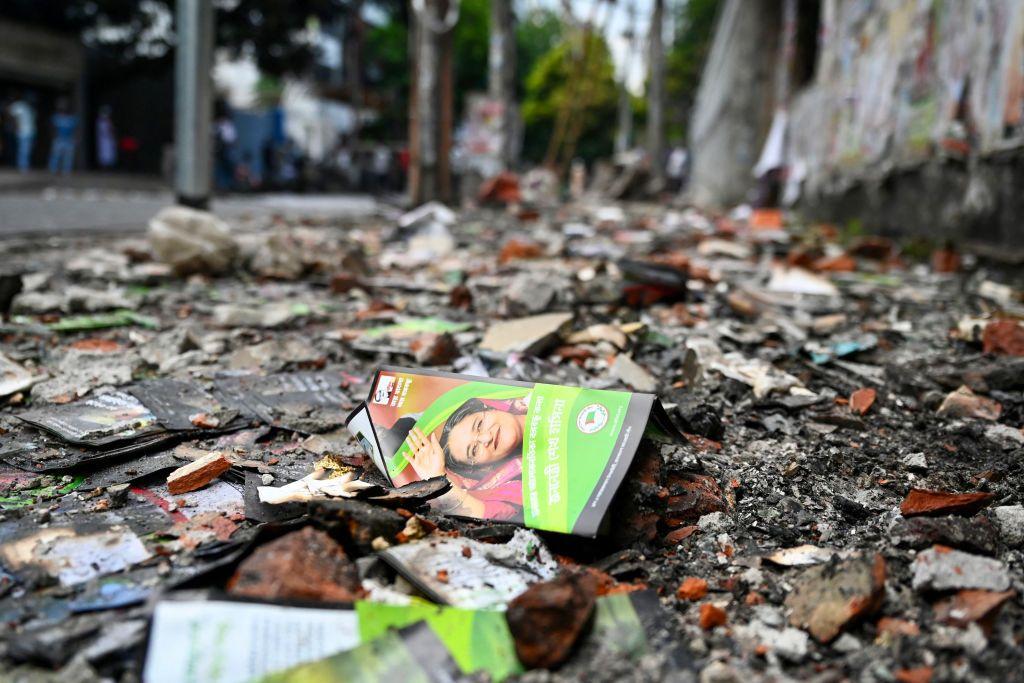 Um panfleto com o rosto de Sheikh Hasina no chão