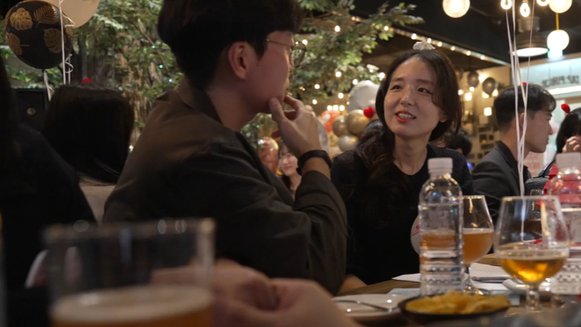 Um homem e uma mulher conversando em uma mesa com comidas e bebidas 

