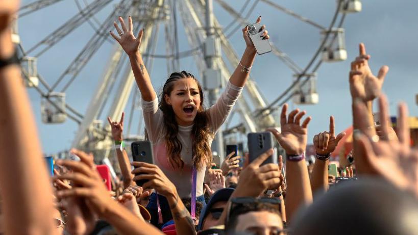 Una mujer celebra en un festival musical en Brasil.