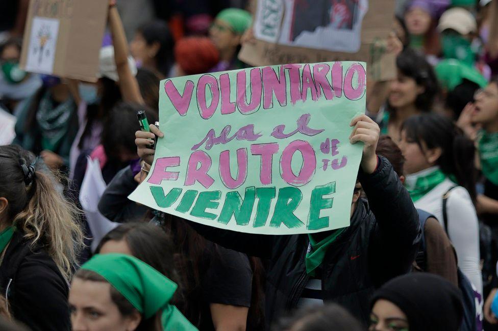 Mujer con una pancarta que dice: "Voluntario sea el fruto de tu vientre"