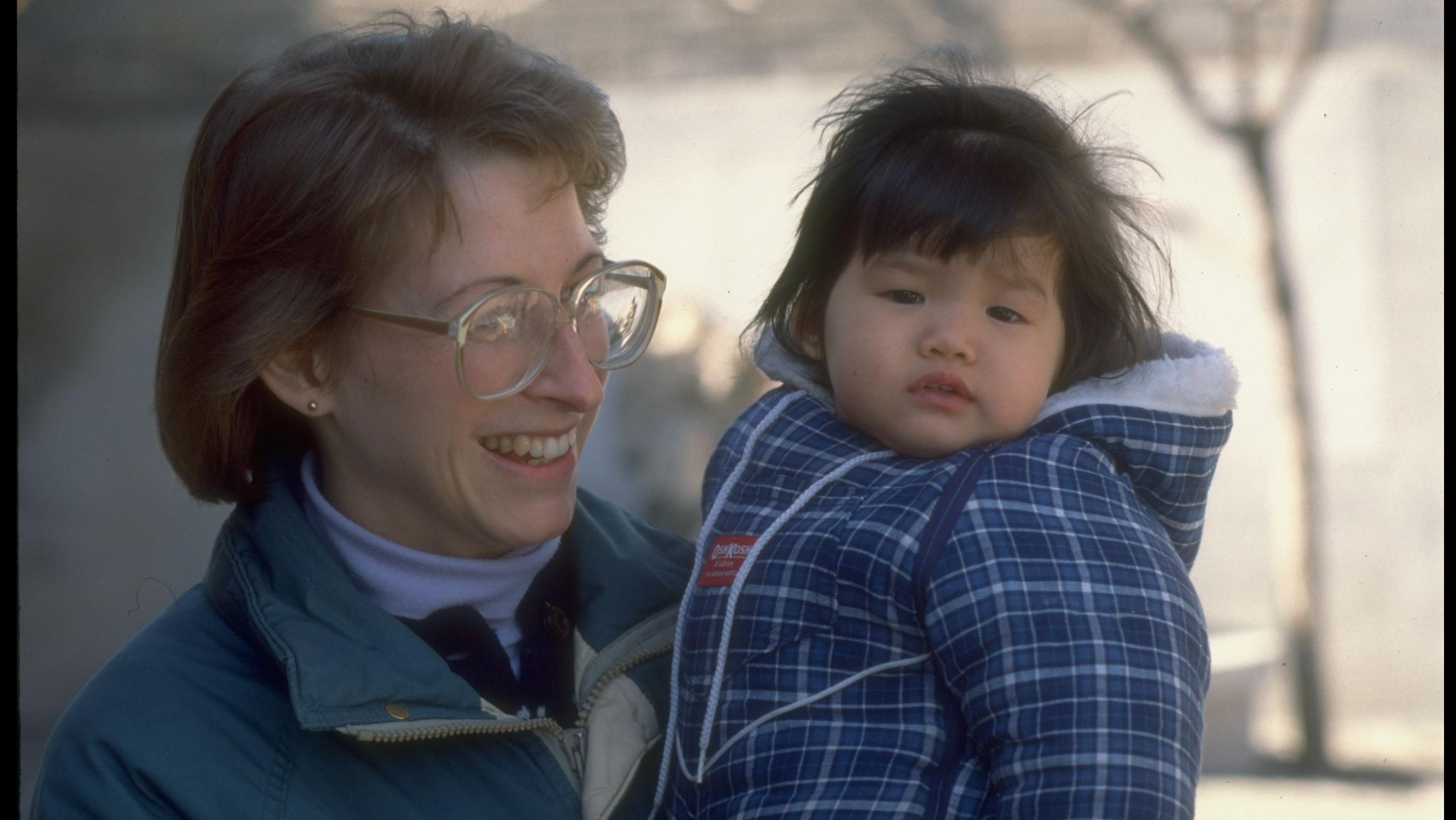 Western would-be-adoptive mother, Sue Eitemiller, holding 1-yr-old Joelle from Tianjin orphanage, re China's abandoned baby problem & foreign adoptions.