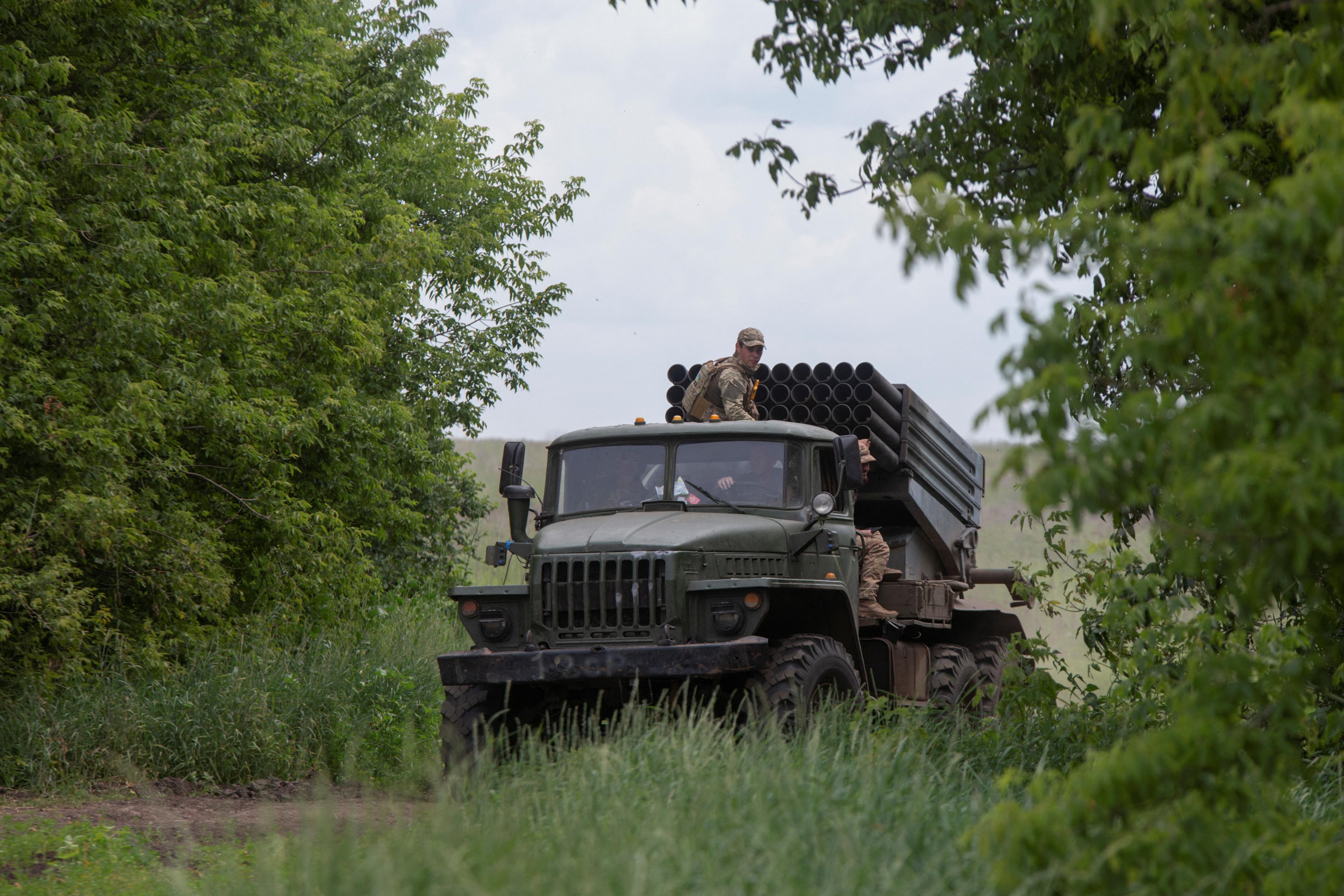 جنود أوكرانيون يركبون شاحنة تحمل نظام صاروخ الإطلاق المتعدد BM-21 Grad بالقرب من خط أمامي في منطقة دونيتسك في 21 يونيو-حزيران