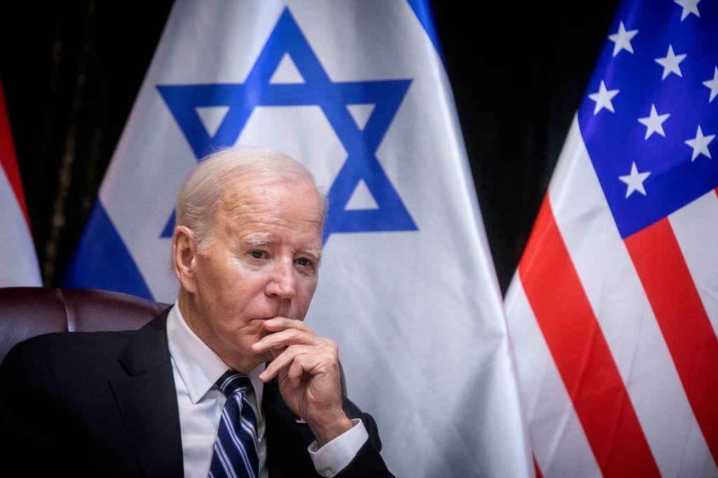 Joe Biden, pensativo, flanqueado por las banderas de Israel y Estados Unidos, en su reciente visita a Israel. 
