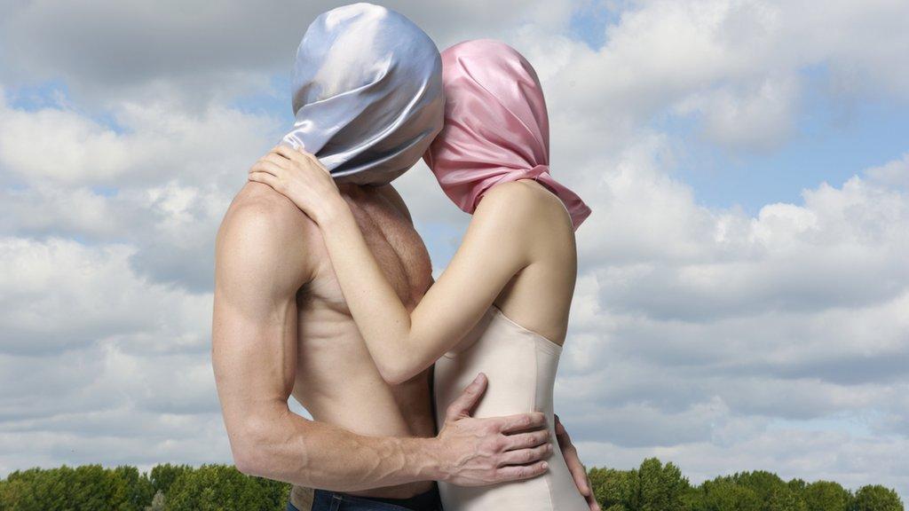 Imagem mostra homem e mulher abraçados com pano cobrindo a cabeça