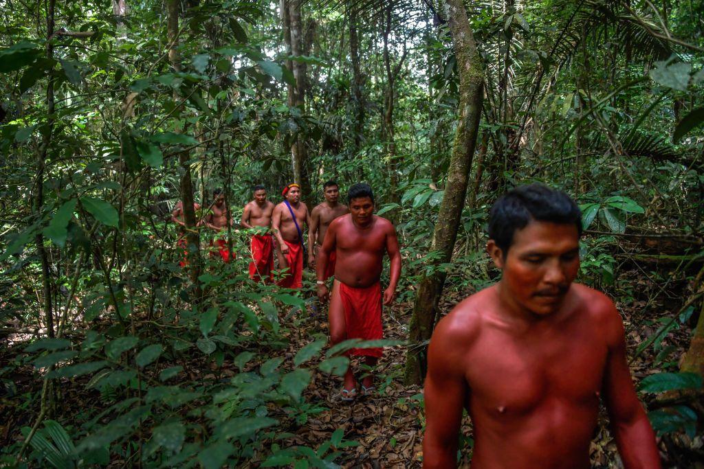 Indígenas amazónicos caminando por la selva.