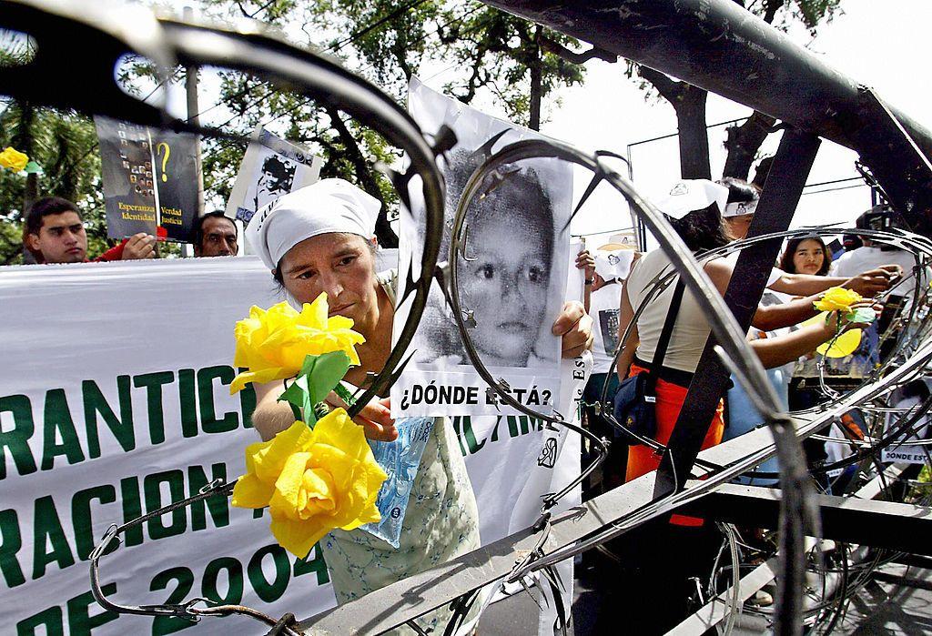 Una madre coloca la foto de su hija desaparecida durante una manifestación en San Salvador, noviembre 2004