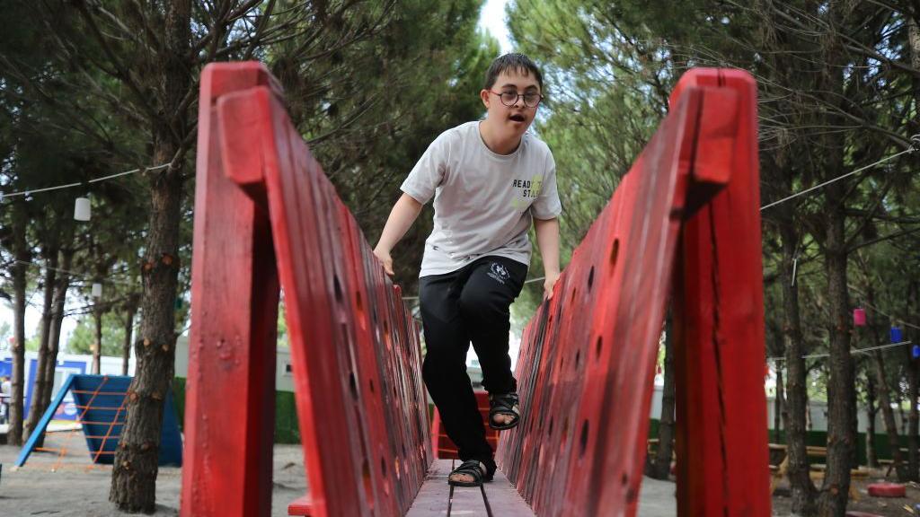 A child with Down Syndrome plays in the park at 