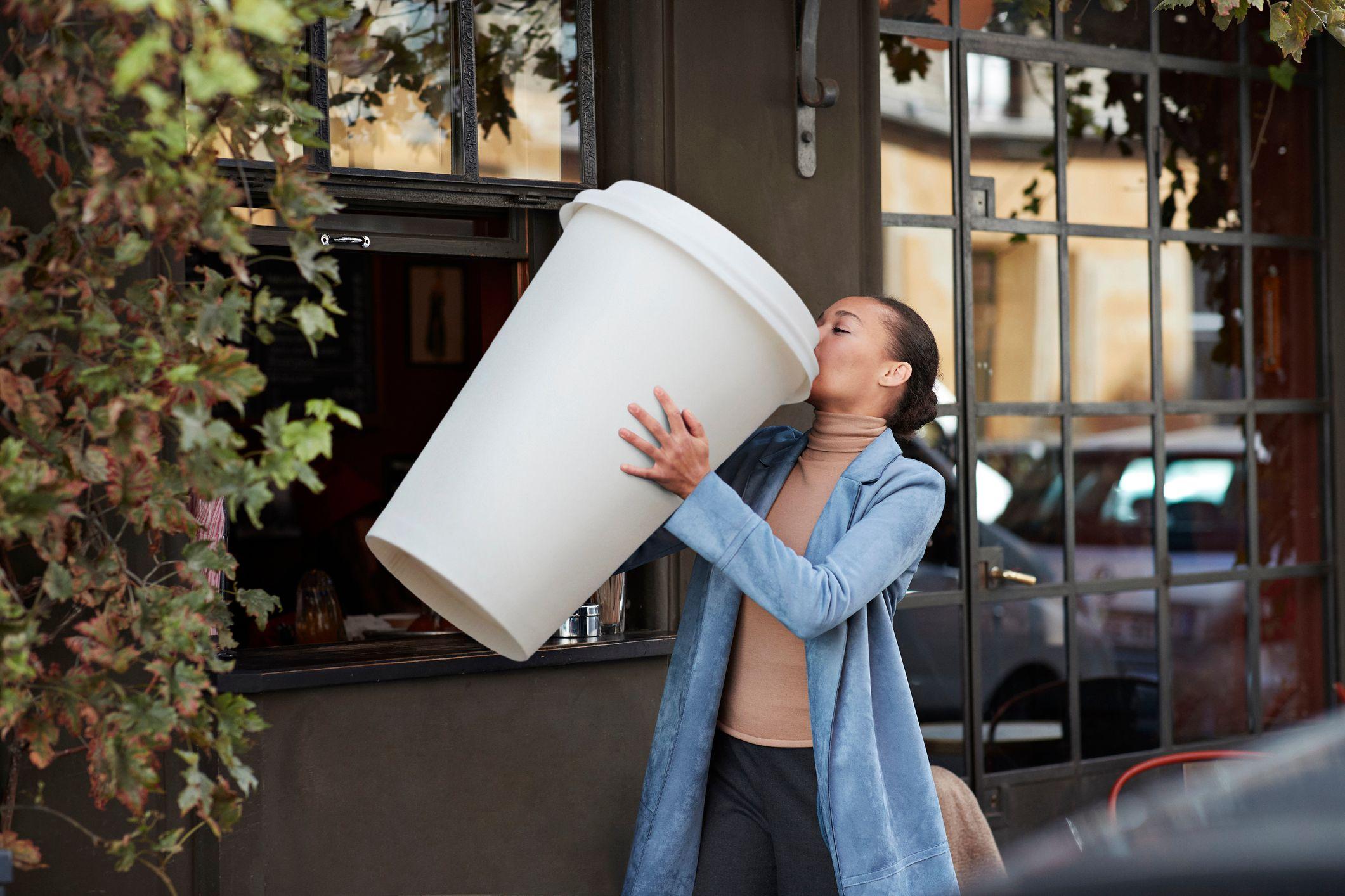 Una mujer con un vaso gigante de café