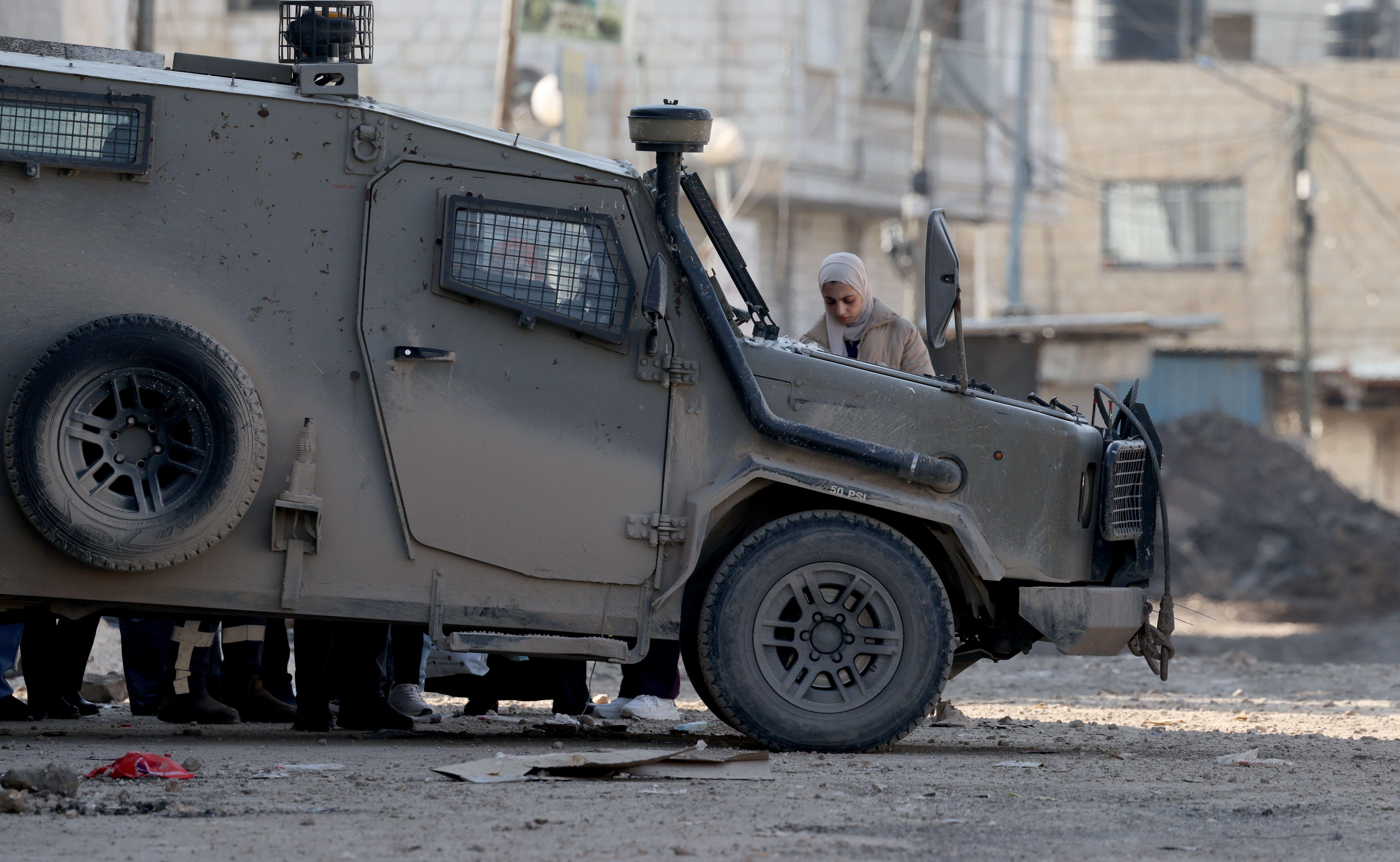 مركبة عسكرية إسرائيلية بجوار فتاة فلسطينية في جنين 29 يناير/كانون الثاني