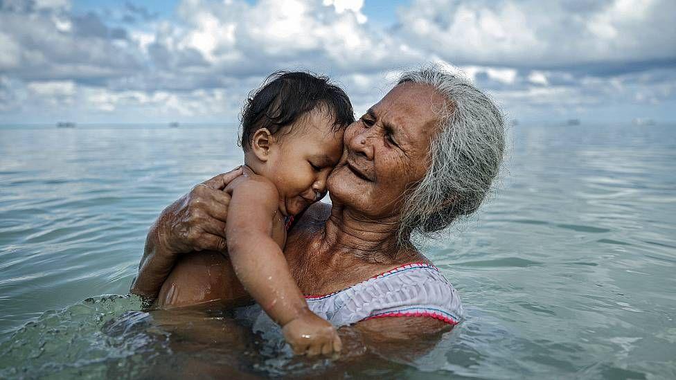 Una abuela en Tuvalu baña a su nieto en una laguna interna