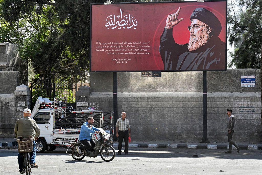 Outdoor colocado em uma rua de Damasco com uma mensagem de condolências do presidente Bashar al-Assad pela morte do líder do Hezbollah, Hassan Nasrallah.