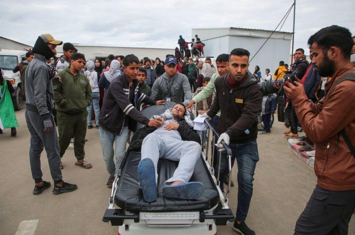 أشخاص ينقلون مريضًا أثناء استقبال السجناء الفلسطينيين بعد إطلاق سراحهم من سجن إسرائيلي، في خان يونس بجنوب قطاع غزة، 8 فبراير، 2025. 