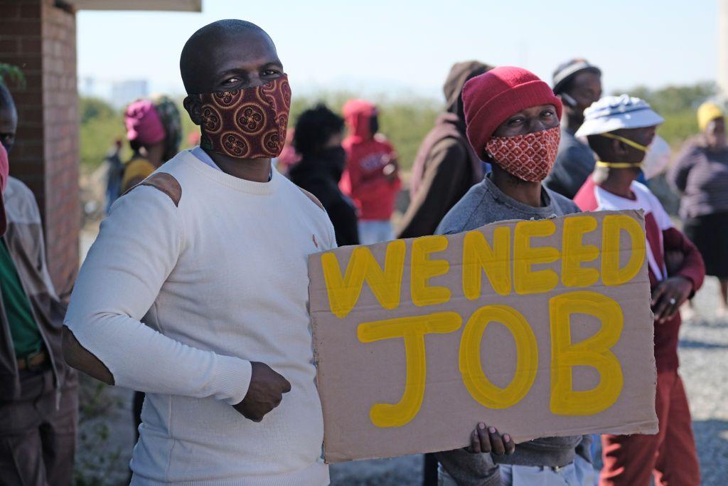 Manifestantes muestran una pancarta cerca de la comunidad minera de Seraleng el 18 de mayo de 2020, en Rustenburgo, Sudáfrica.