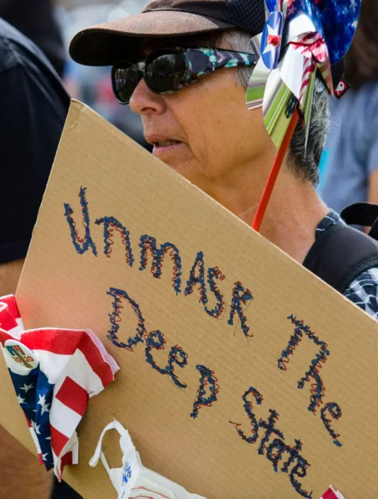 Apoiador de Trump segura cartaz contra o Estado Profundo 