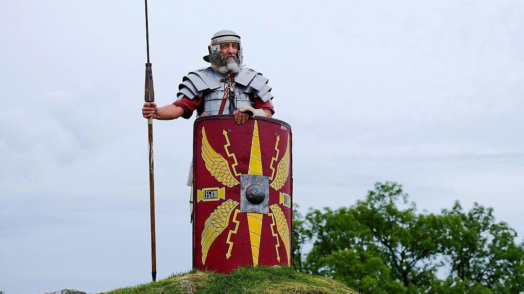 Um homem vestido de soldado romano.