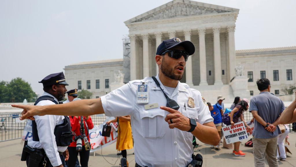 Un agente de policía controlando protestas al frente de la Corte Suprema