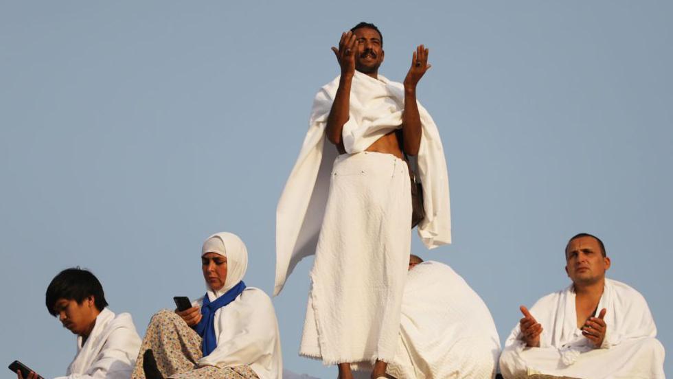 حجاج يتضرعون إلى الله  بالدعاء أعلى جبل عرفات في 15 يونيو/حزيران في 2024.