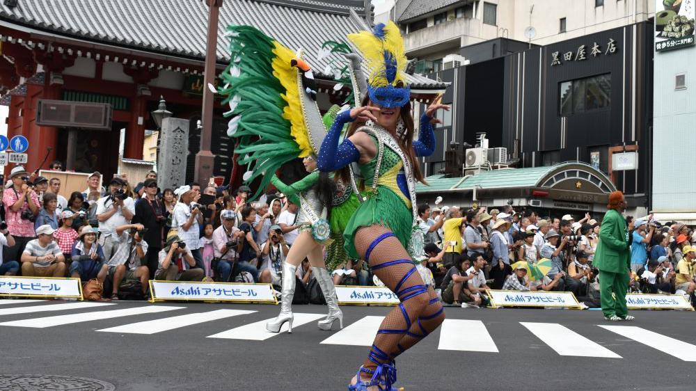 A foto mostra uma mulher desfilando com as cores da bandeira do Brasil.