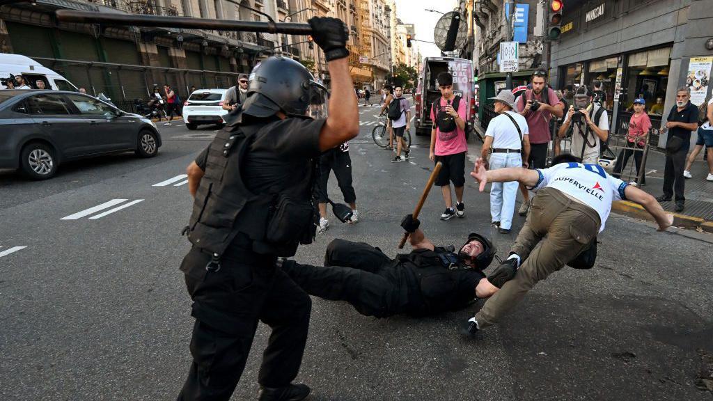 Policía intenta golpear a un manifestante