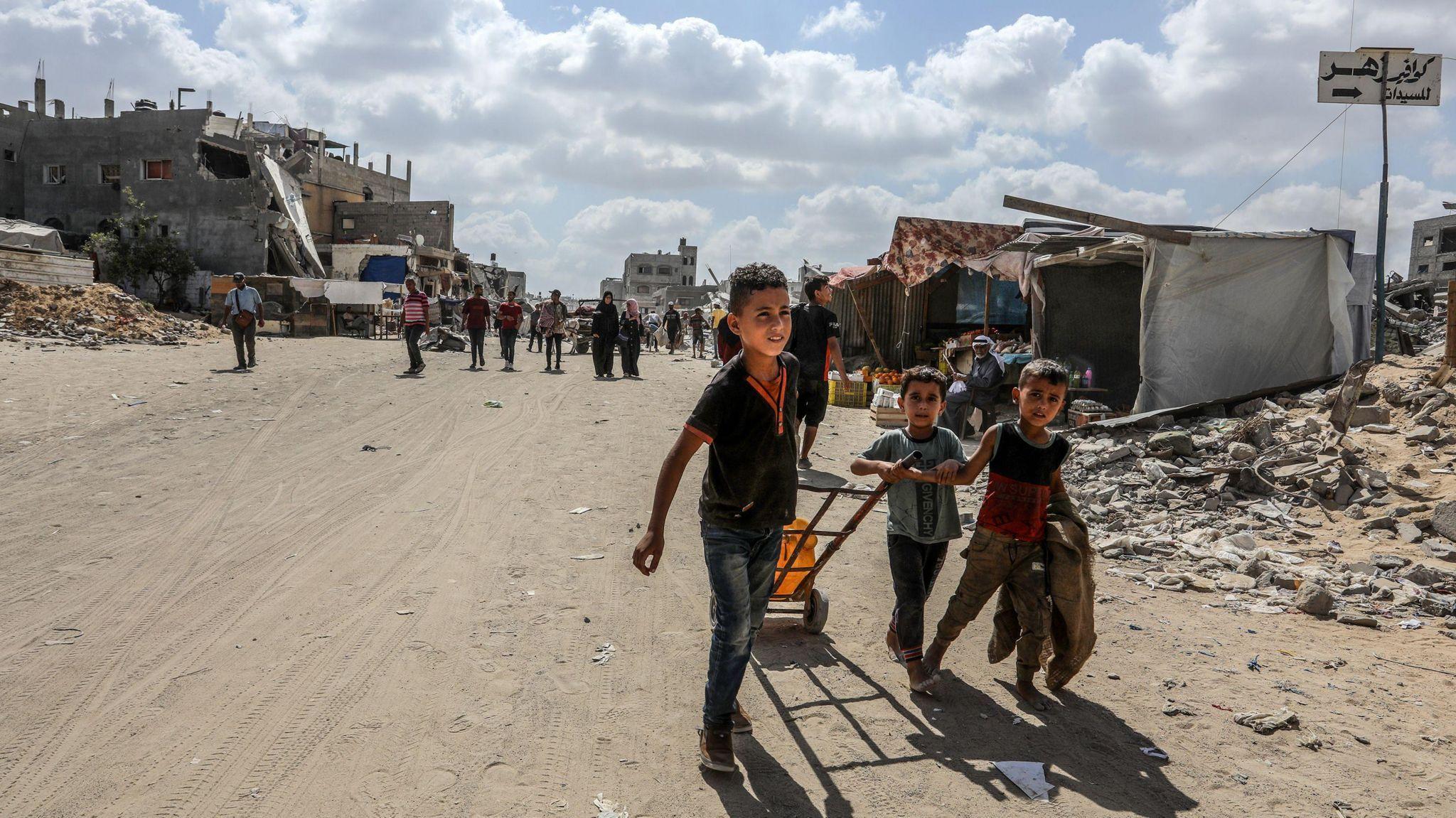 Niños tiran de una carretilla en Gaza.