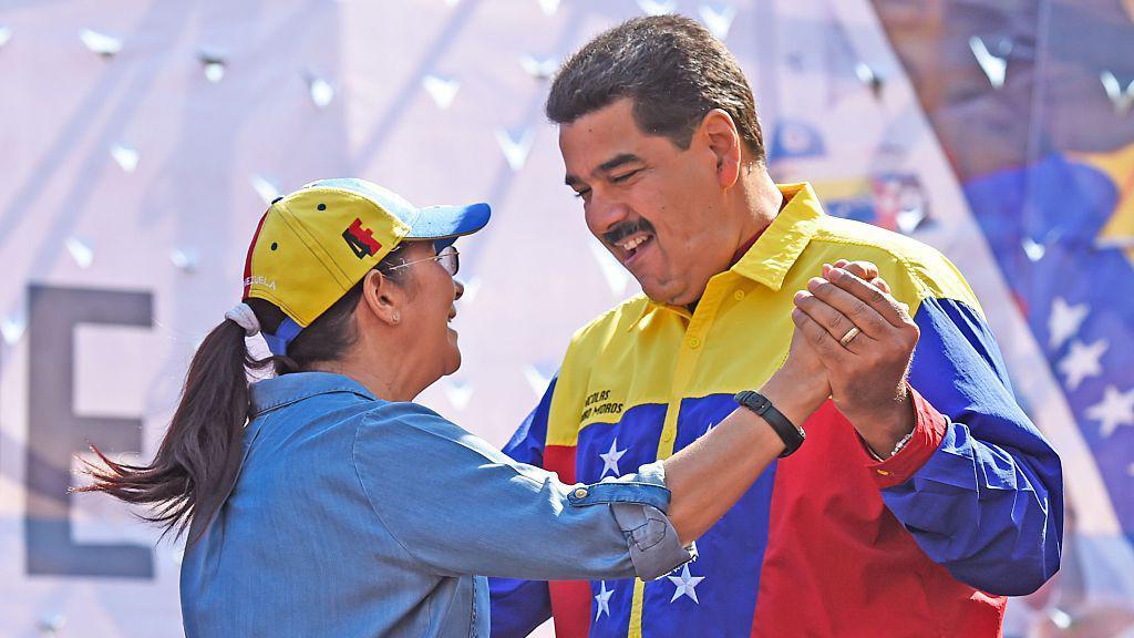 O presidente venezuelano Nicolás Maduro (R) dança com sua esposa Cilia Flores durante uma manifestação contra a decisão dos Estados Unidos de renovar as sanções a vários altos funcionários venezuelanos, em Caracas, em 12 de março de 2016.