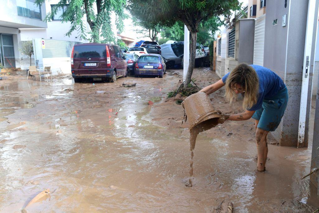 Mulher retira o barro de sua casa. 