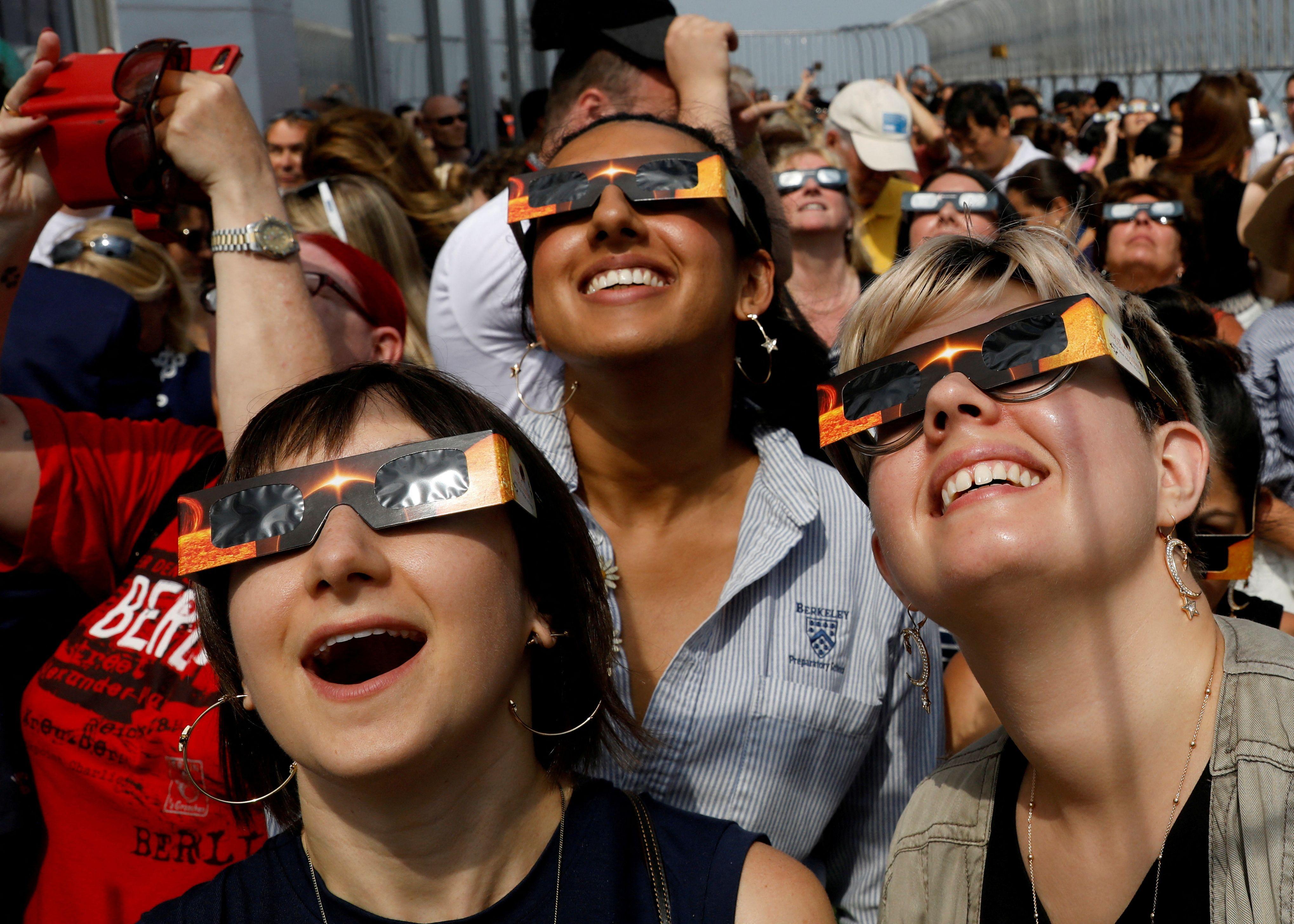 Personas miran un eclipse solar con gafas