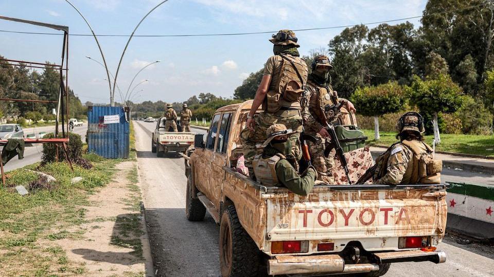 قوات تابعة للمرحلة الانتقالية في دمشق أثناء تجولها في مدينة اللاذقية.