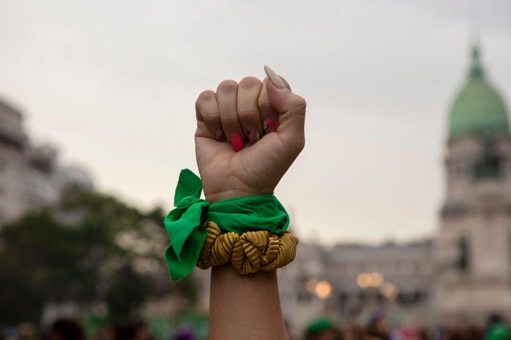 Una mujer levanta el puño con el pañuelo verde durante la marcha del 8 de marzo