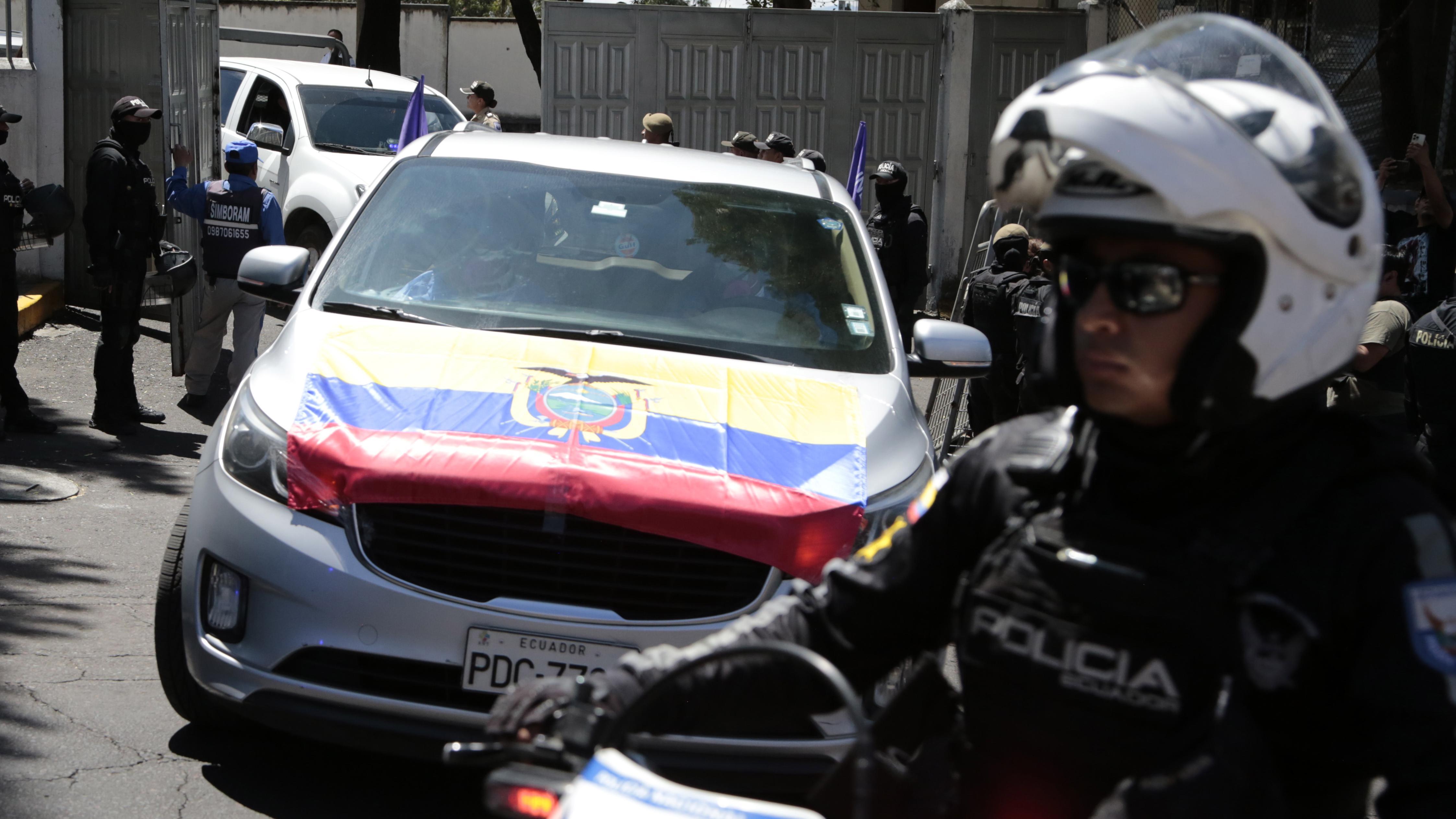 Um policial guarda um carro com a bandeira equatoriana