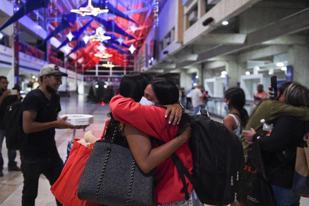 Duas mulheres venezuelanas se abraçam no aeroporto após tentativa de emigrar