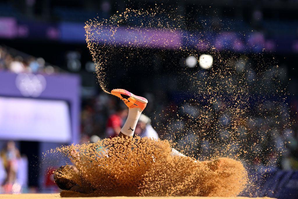 Pé de atleta é visível em meio a areia após um salto