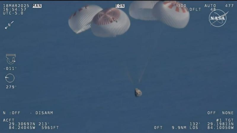 Cápsula con los astronautas cayendo con 4 paracaídas.