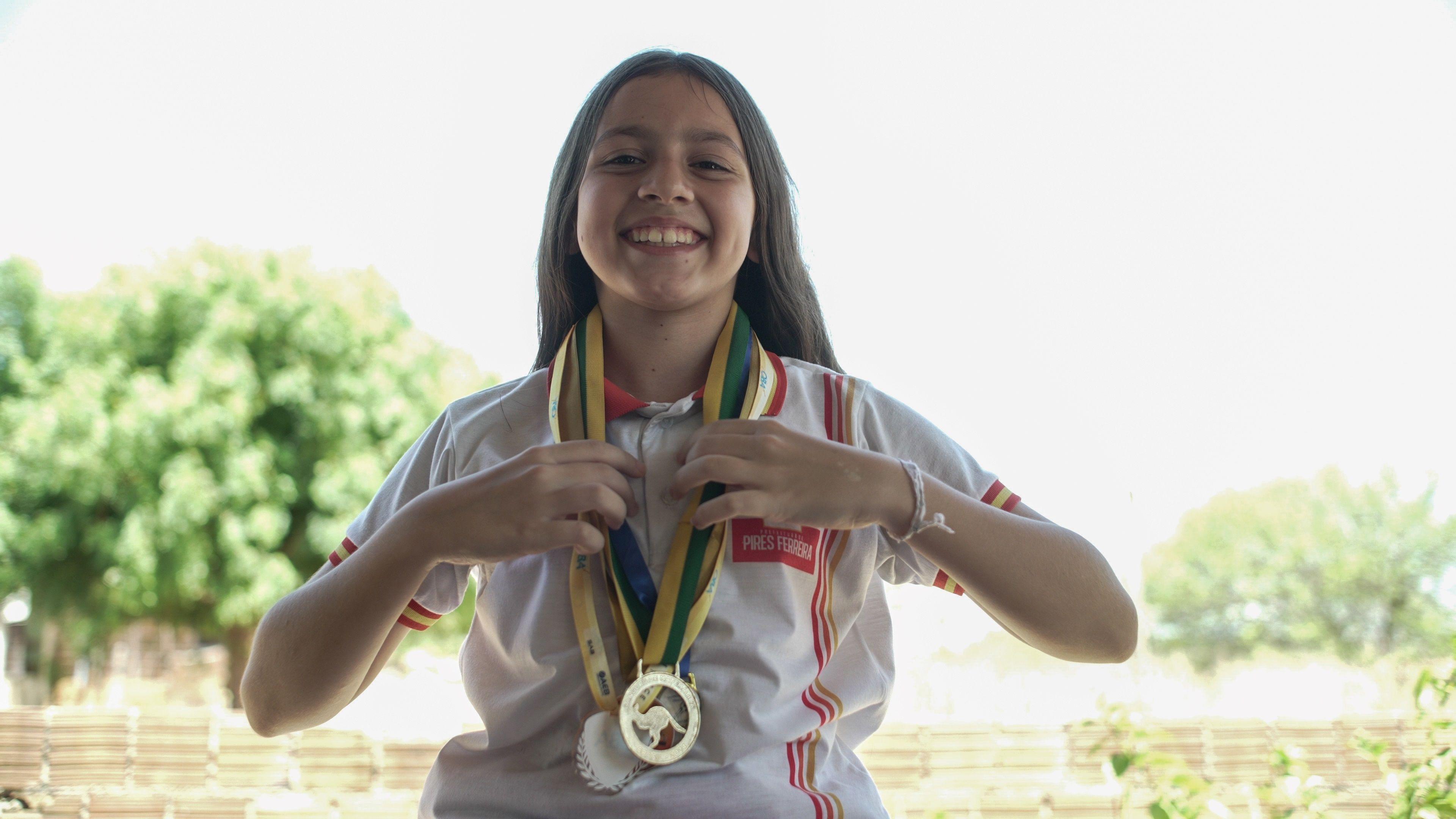 Aluna com várias medalhas no pescoço