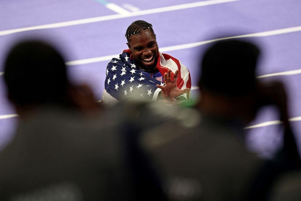 Noah Lyles celebrates the medal.