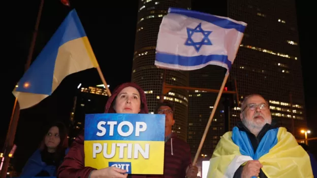 Orang-orang di kota Tel Aviv, Israel, mengibarkan bendera Ukraina dan Israel selama protes terhadap invasi militer Rusia ke Ukraina pada Maret 2022.