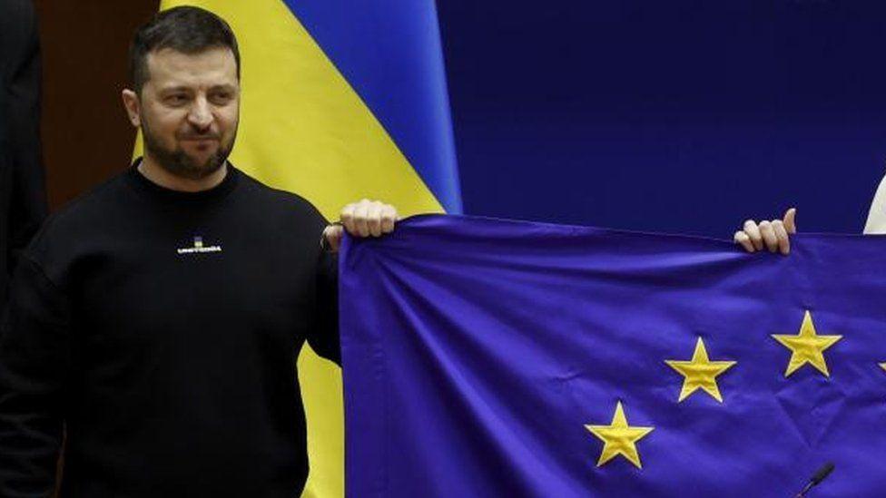 Volodymyr Zelensky sujeta una bandera de la UE