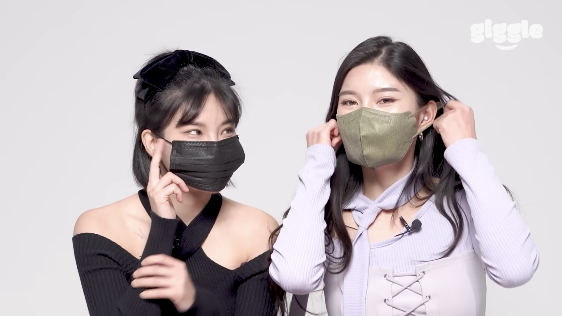 Dua perempuan menggunakan masker