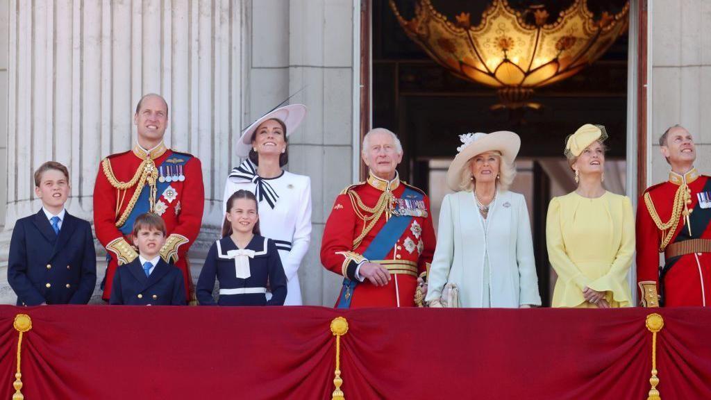Família real britânica paramentada em uma varanda