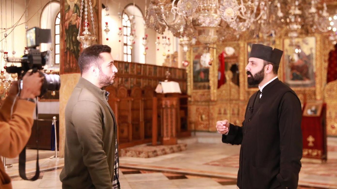 مراسل بي بي سي مهند توتنجي مع الكاهن عيسى ثلجية من داخل كنيسة المهد في بيت لحم