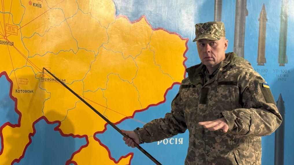 Oleksandr Sushchenko, vestido de militar, señala un mapa de Ucrania con un puntero