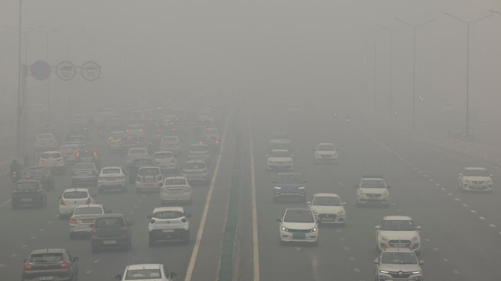 Vehículos en una autopista en Delhi en medio de una nube gris de contaminación