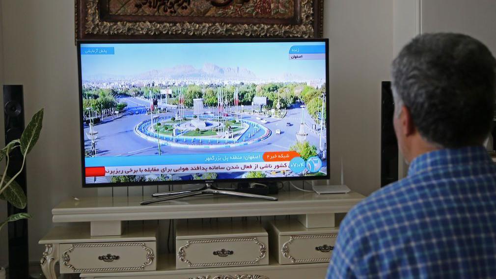 Un hombre mira los programas de noticias iraníes.