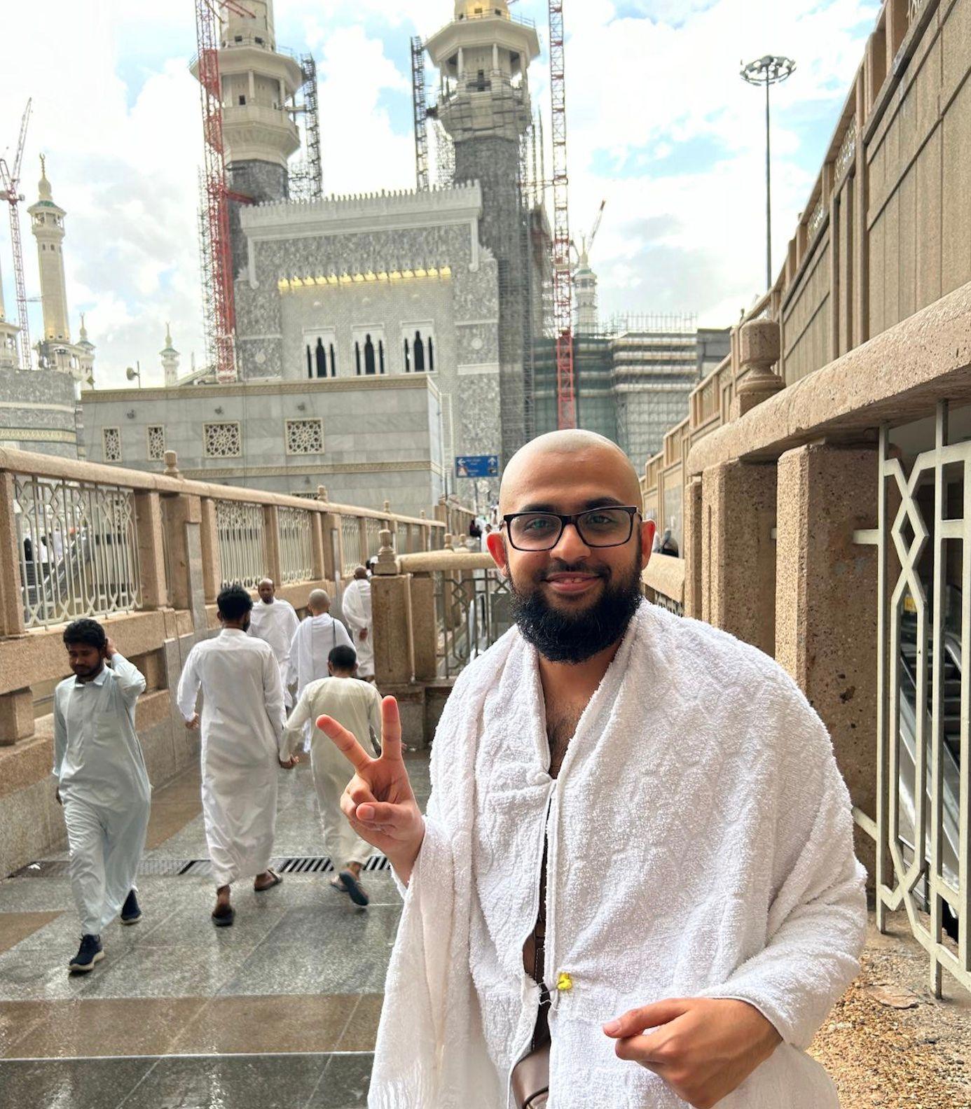 Farouk Abdel Wahab giuving the positive V sign with his fingers in Mecca, after visiting by buying transportation and documentation himself