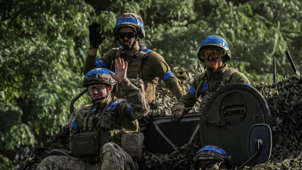 Tres soldados ucranianos sentados sobre un tanque en la región de Sumy