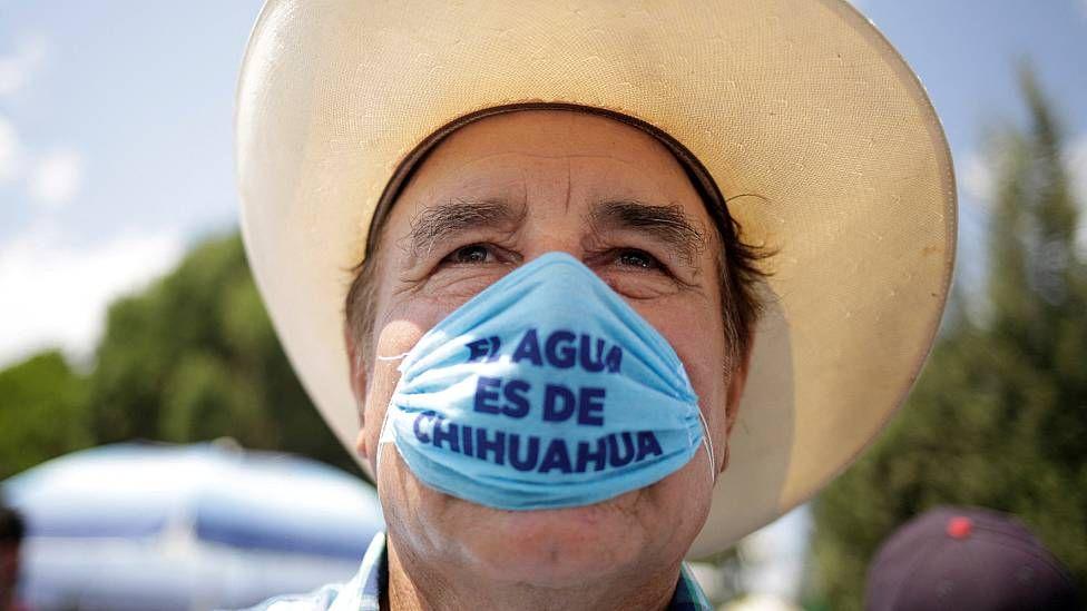 Agricultor con una mascarilla que dice "el agua es de Chihuahua"