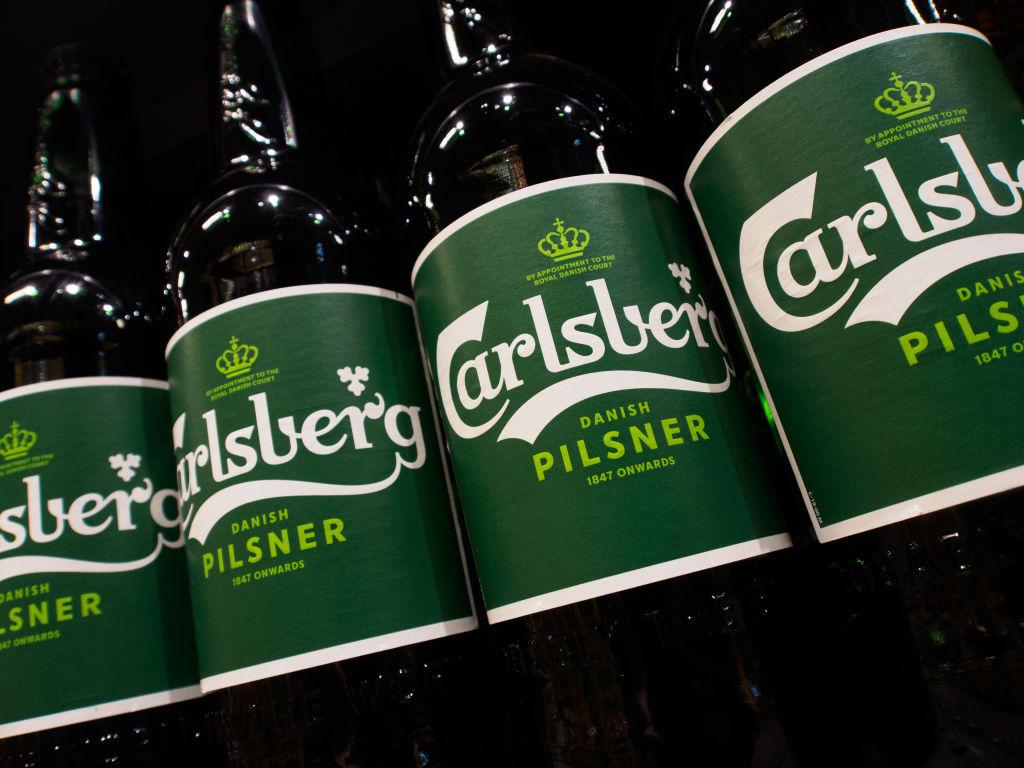 Garrafas da cerveja Carlsberg em prateleira de supermercado