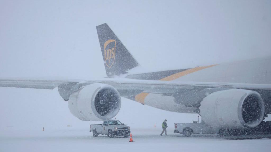 Foto de um avião sob a neve.